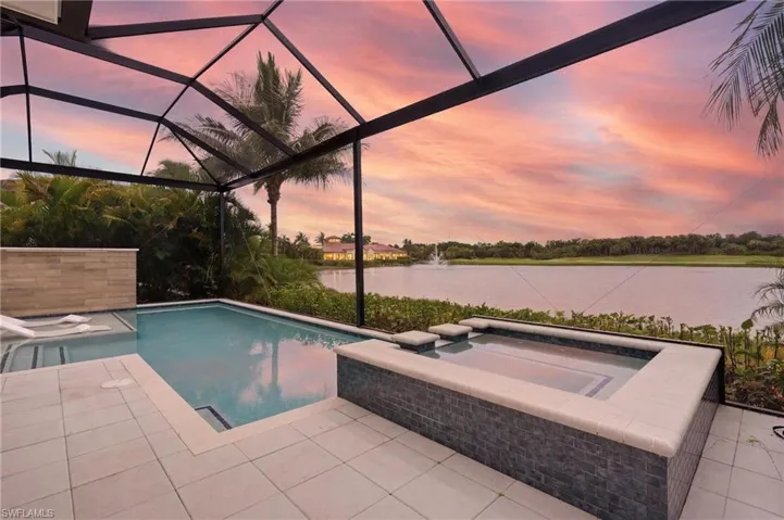 Screened lanai featuring a swimming pool, integrated spa, and expansive water views