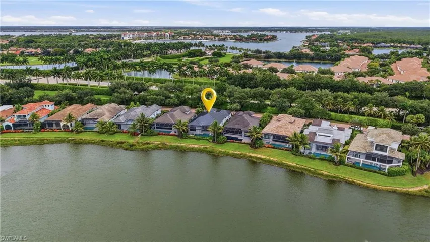 Waterfront property featuring a screened lanai, private swimming pool, and manicured lawn