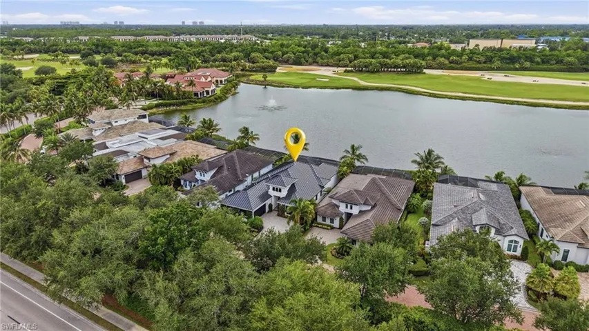 Waterfront property with a dark-tiled roof and light-colored exterior