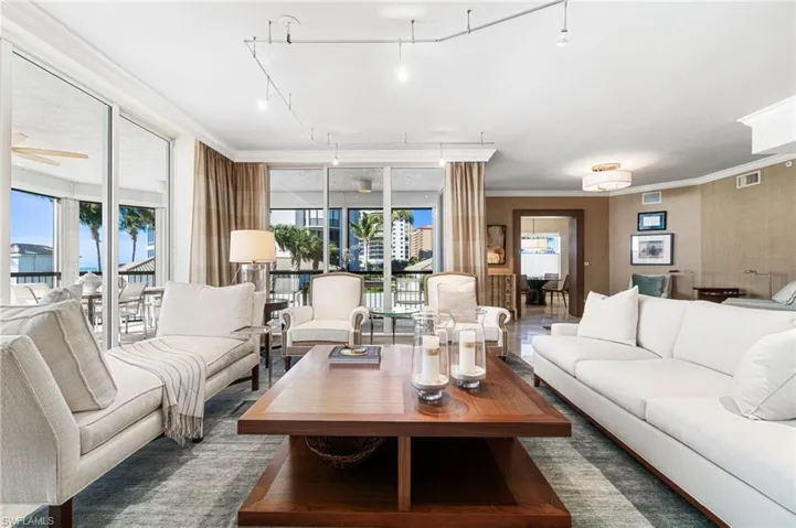 Living room featuring ceiling fan, plenty of natural light, ornamental molding, and rail lighting