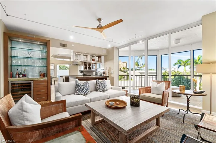 Living room with ceiling fan, beverage cooler, and sink