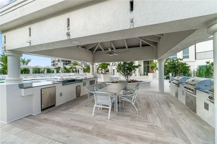 View of patio / terrace with a grill, a community pool, ceiling fan, and exterior kitchen
