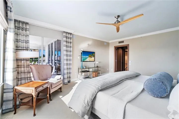 Carpeted bedroom with ornamental molding and ceiling fan
