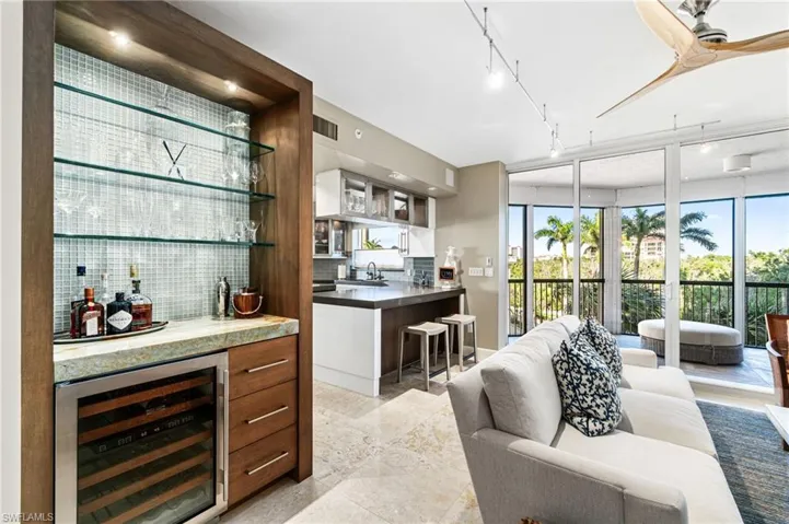 Bar with wine cooler, tasteful backsplash, sink, white cabinetry, and rail lighting