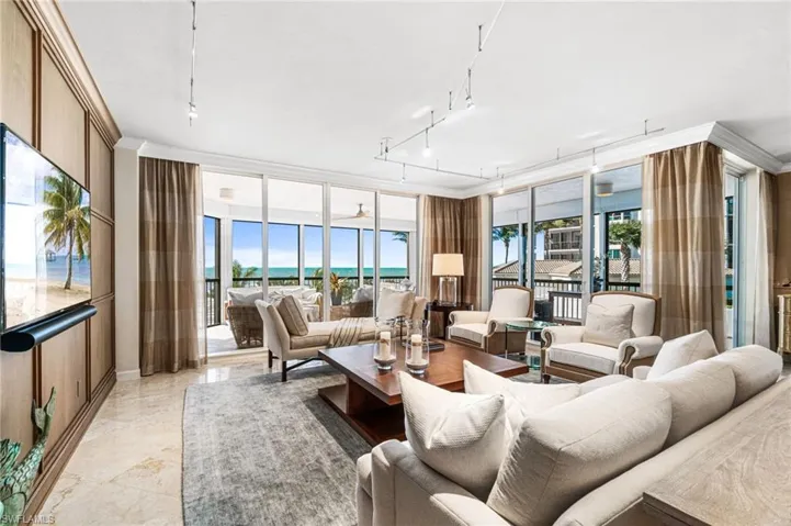 Living room with rail lighting, a water view, and a healthy amount of sunlight