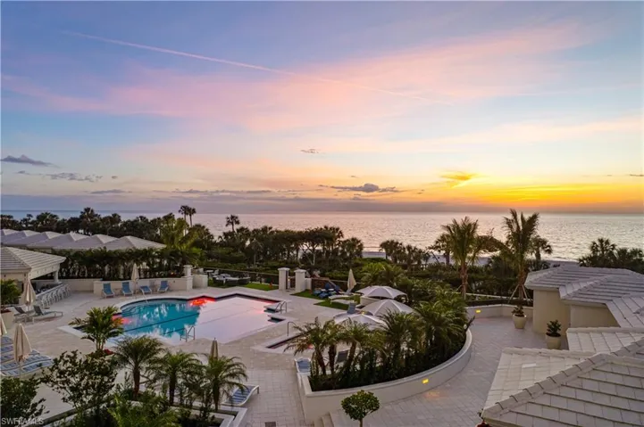 Pool at dusk with a patio and a water view