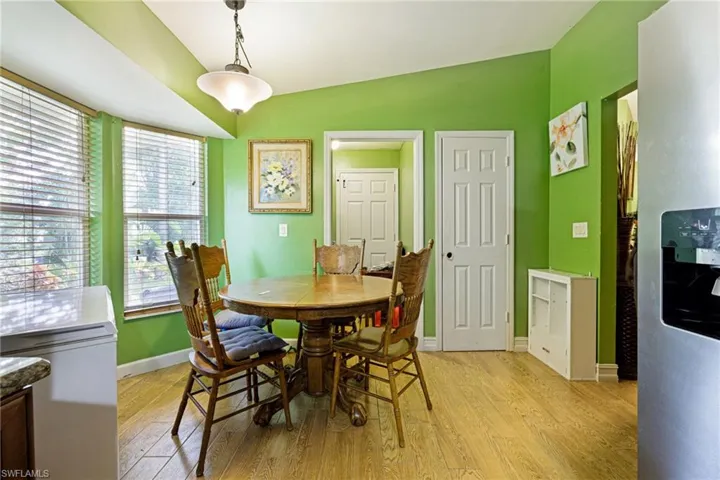 Dining room with light wood-type flooring and vaulted ceiling