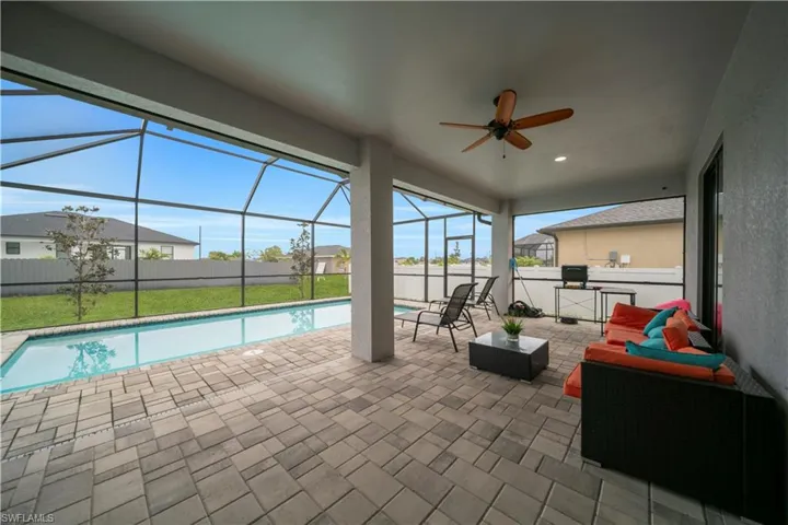View of pool with glass enclosure, a patio area, and a sunroom