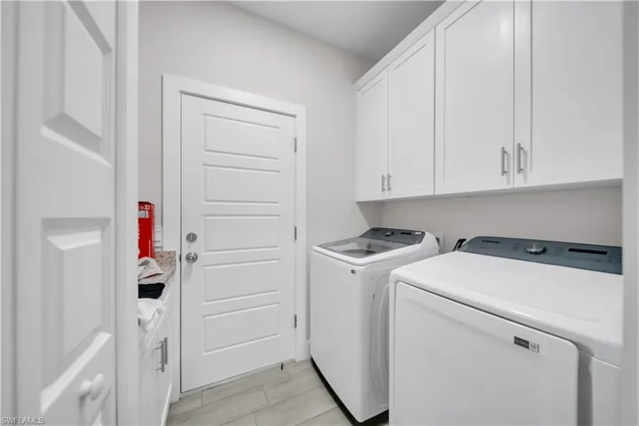 Washroom featuring cabinet space and washer and clothes dryer