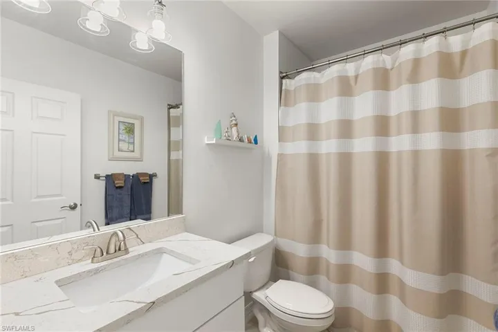 Bathroom with vanity and curtained shower