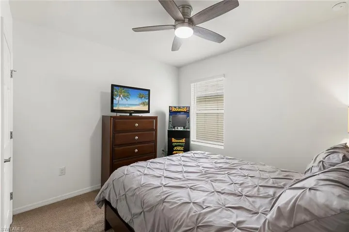 Carpeted bedroom with baseboards and ceiling fan