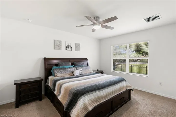 Bedroom with light carpet and ceiling fan