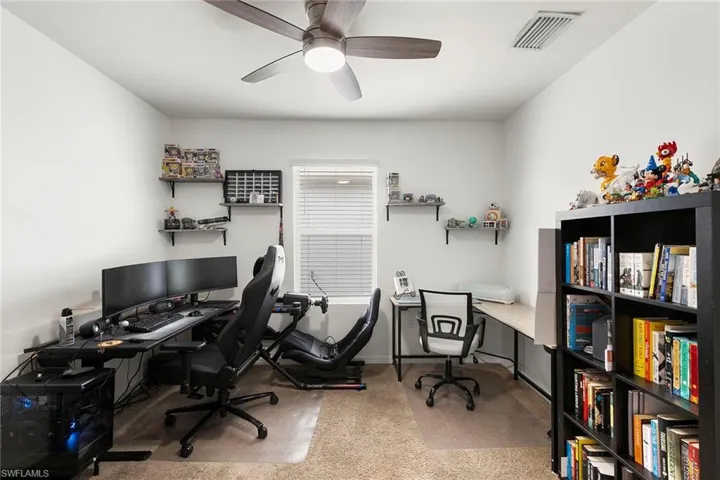 Office area with light carpet and a ceiling fan