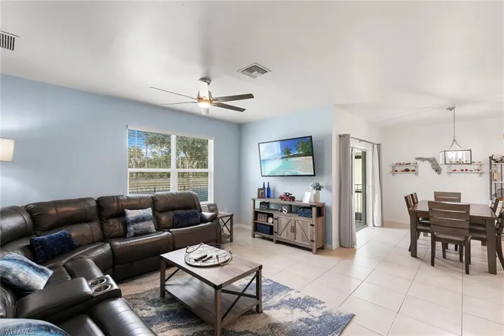 Living room with light tile patterned flooring and a ceiling fan