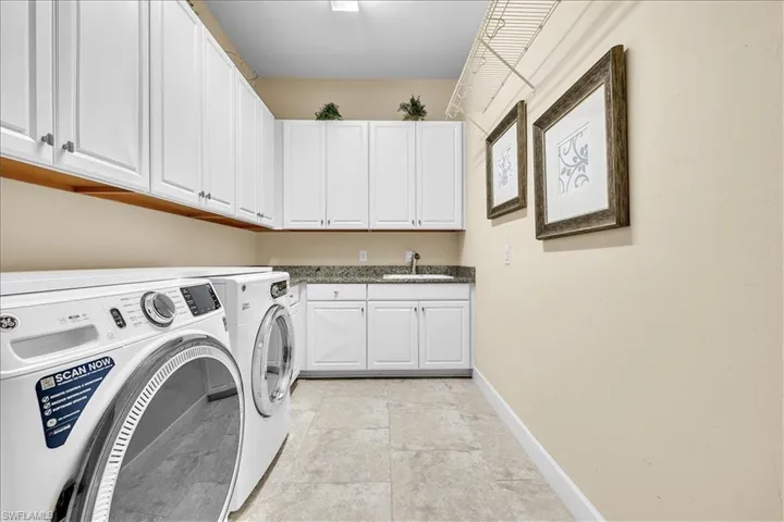 Large laundry room  with built in shelving and laundry sink