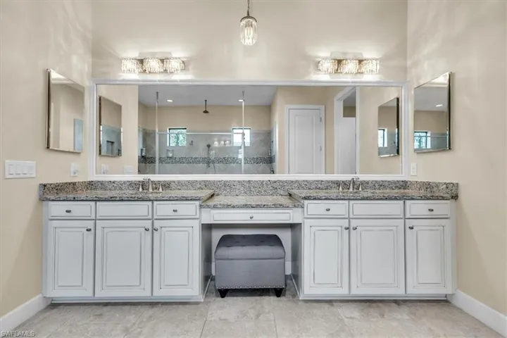 -feauturing elegant lighting and a framed mirror with make-up vanity