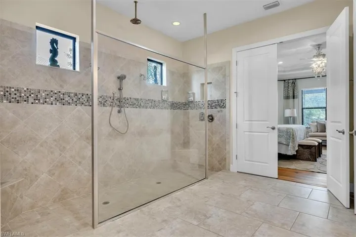-featuring an oversized walk-in shower accessible from either side and overhead rain shower faucet