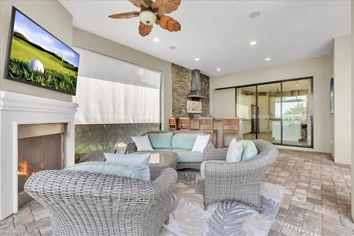 Lanai featuring outdoor kitchen, fireplace, privacy shade, pool/spa, and view of #1 fairway and green