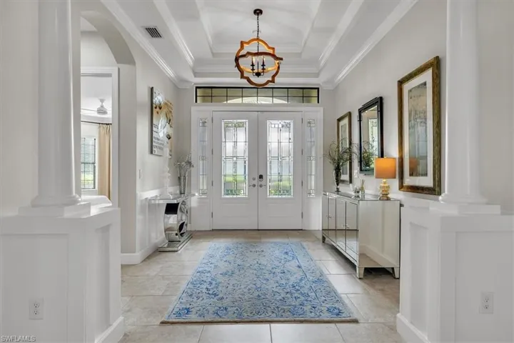 Grand entry with arches, columns, tray ceilings and crown molding