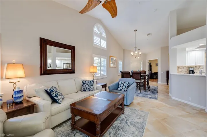 Living room with volume ceiling, plantation shutters, additional dining area