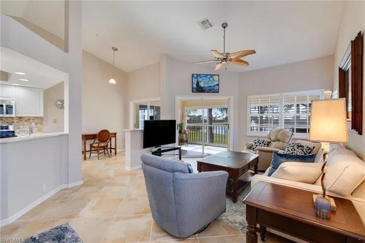 Living room featuring volume ceilings/ open area to kitchen and screened balcony