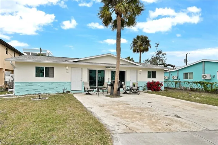 Back of house with a yard and a patio area