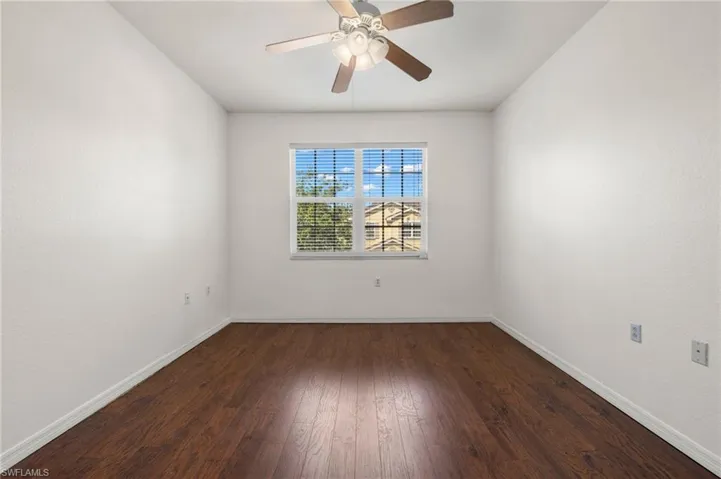 Spare room with dark wood finished floors and ceiling fan