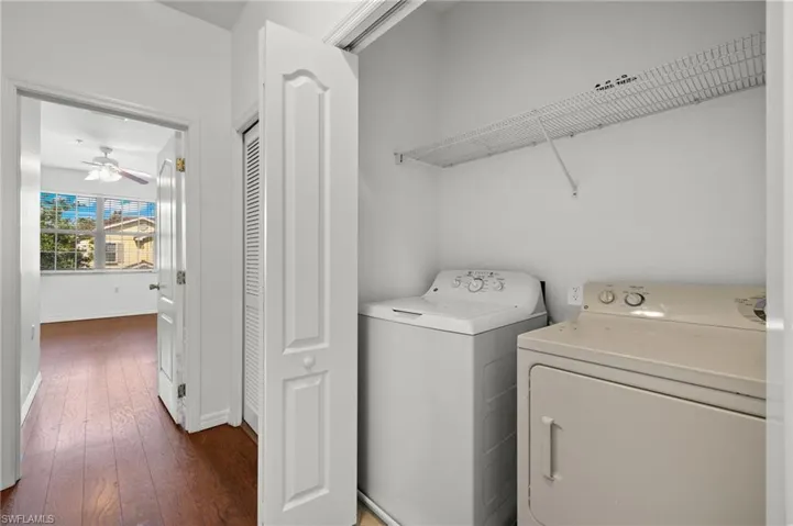 Laundry room featuring dark wood-style floors, separate washer and dryer, and ceiling fan