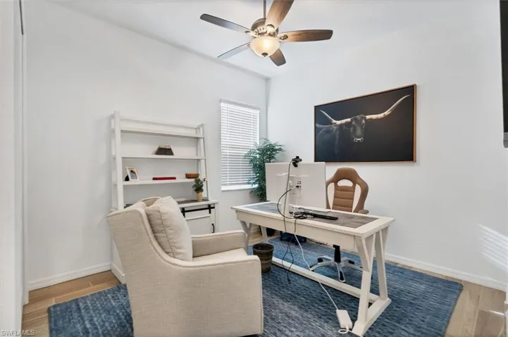 Office space with ceiling fan and light wood-type flooring