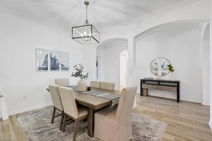 Dining area featuring ornamental molding and a chandelier
