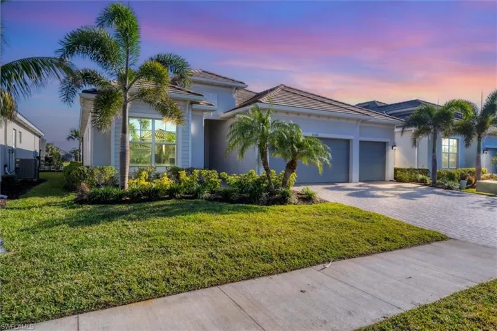 View of front of property with a garage, a yard, and central AC unit