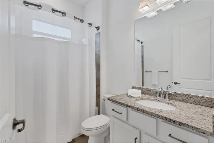 Bathroom featuring vanity, hardwood / wood-style floors, and toilet