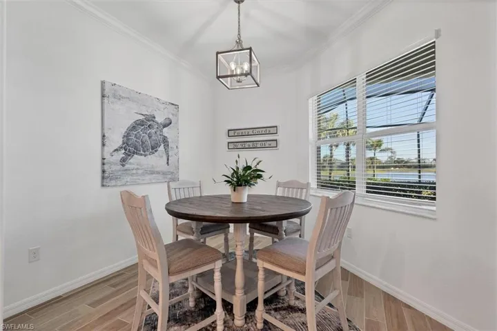 Dining space featuring ornamental molding, light hardwood / wood-style floors, and a chandelier