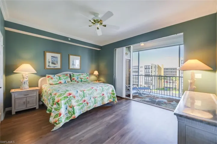 Bedroom featuring access to outside, dark wood-style flooring, crown molding, and a ceiling fan