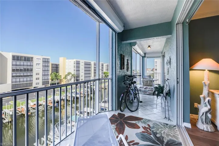 Balcony with a sunroom and a water view