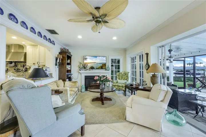 Custom-milled baseboards, trim, crown molding & fireplace; large neutral tile on diagonal.