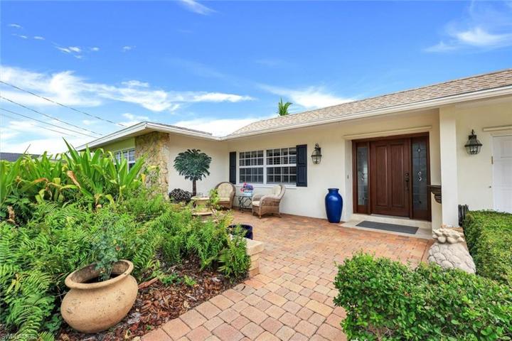 Warm and welcoming paved courtyard entry, fountain & custom front door