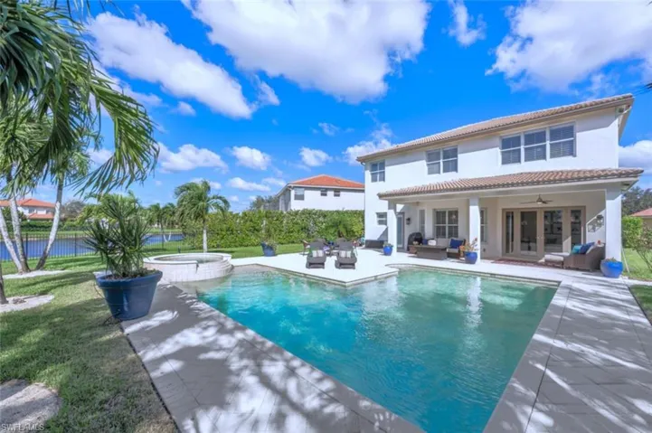 View of pool with an in ground hot tub, outdoor lounge area, ceiling fan, a patio, and a lawn
