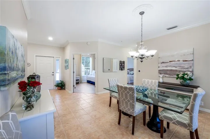 Dining area with ornamental molding, a chandelier, light tile patterned flooring, and recessed lighting