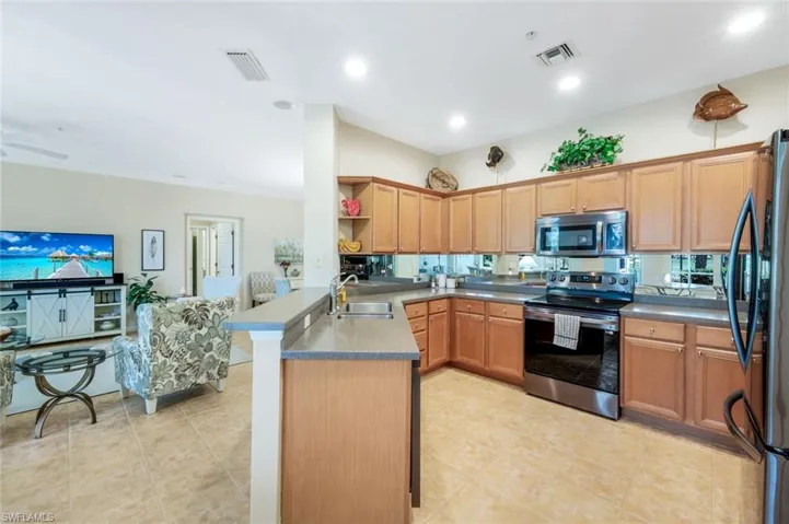 Kitchen with stainless steel appliances, open floor plan, light tile patterned flooring, a peninsula, and recessed lighting