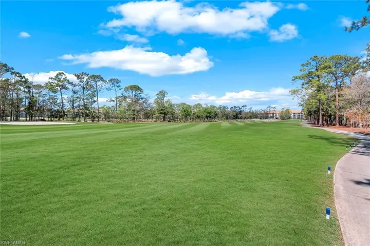 Surrounding community featuring golf course view and a lawn