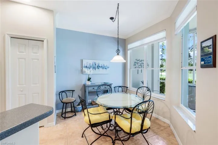 Dining space featuring crown molding and light tile patterned floors