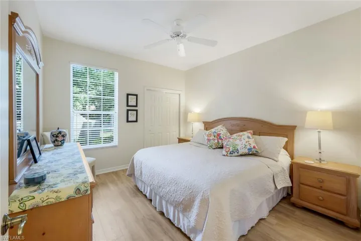 Bedroom with light wood-style flooring, a closet, and a ceiling fan