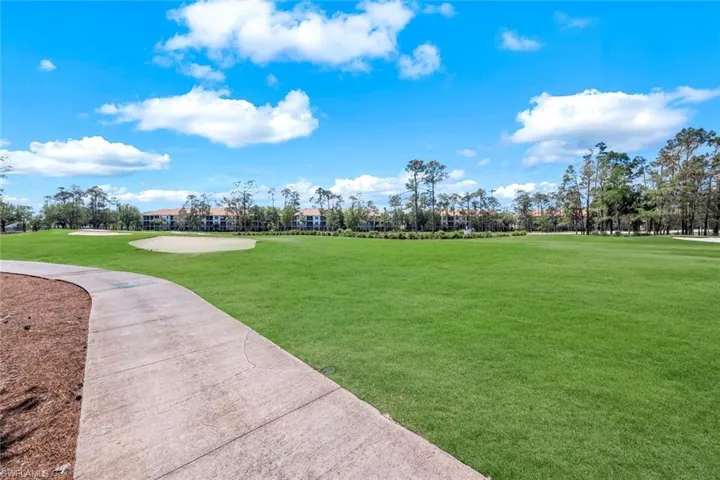 View of community featuring a lawn and view of golf course