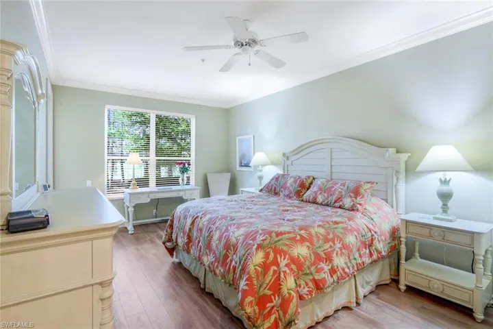 Bedroom featuring ornamental molding, wood finished floors, and a ceiling fan