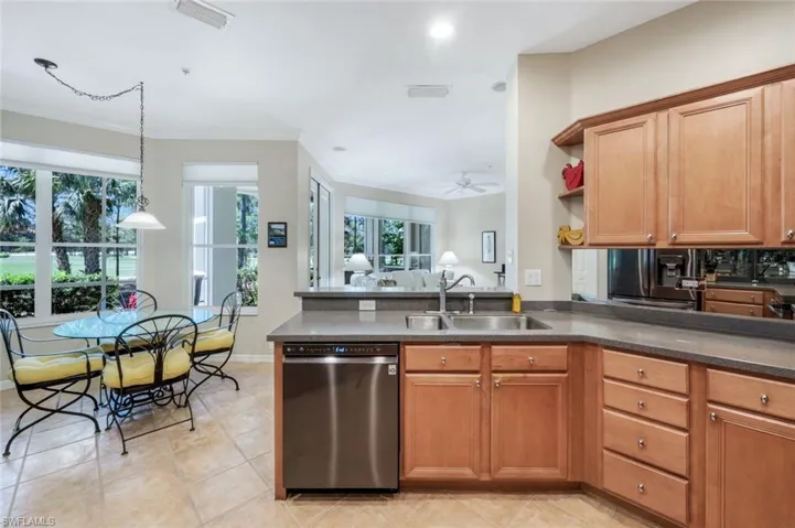 Kitchen with open shelves, stainless steel dishwasher, a peninsula, brown cabinetry, and a ceiling fan