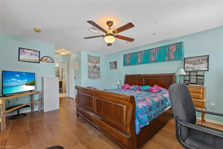 Bedroom with baseboards, visible vents, and ceiling fan