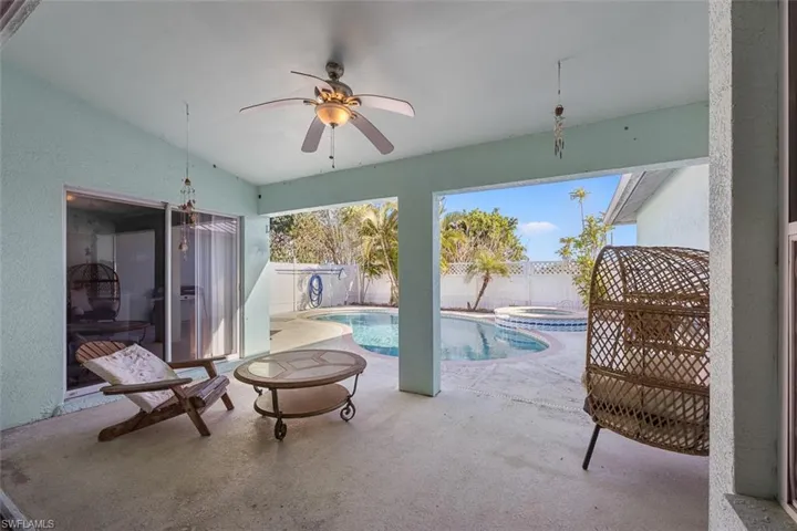 View of pool featuring a patio, a fenced backyard, a pool with connected hot tub, and ceiling fan