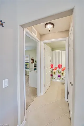 Corridor featuring light colored carpet