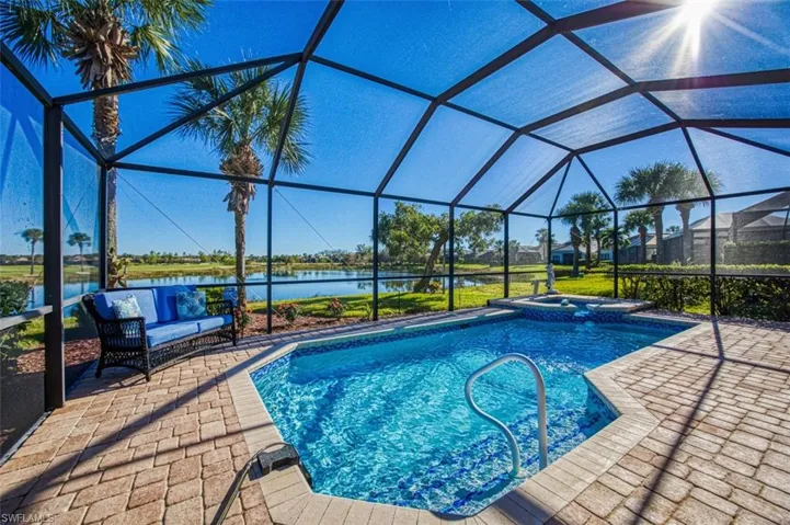 View of swimming pool with a lanai, a patio area, and a water view